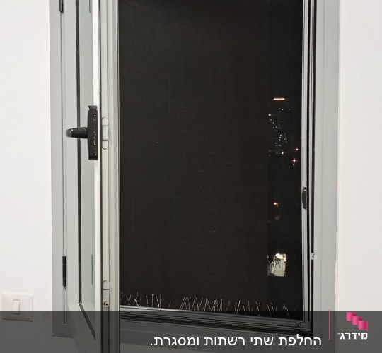 חלון פתוח עם תריסים כהים